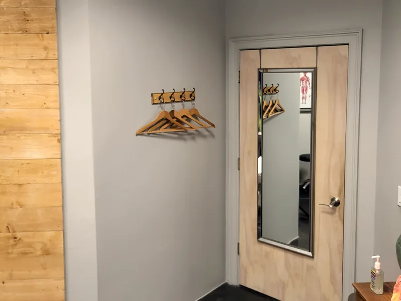 Full-length mirror, hangers and the door of the private treatment room in Lake Mary, FL